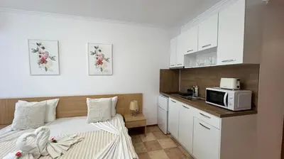 a small bedroom with a bed and a microwave at KAYA Atelie 1 Sunny Beach in Sunny Beach