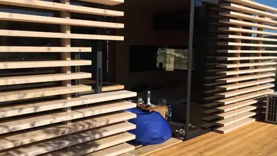 a room with a wall of wood and a mirror at Firstline Beach Camp in Sozopol