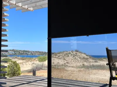 a view of the beach from a porch with a chair at Firstline Beach Camp in Sozopol