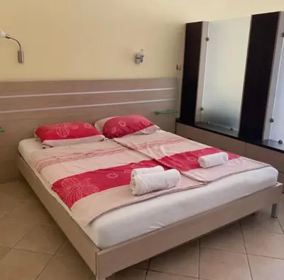 a large bed with red pillows and a mirror at Central Beach Apartament in Sunny Beach