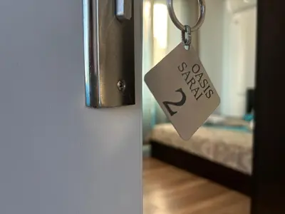 a keychain hanging from a door with a room with a bed at Вила Оазис Сарай - Царево in Tsarevo