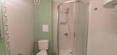 a bathroom with a shower and a toilet and a glass shower at Central Beach Ravda Apartments in Ravda