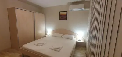 a small bedroom with a white bed with two pillows at Central Beach Ravda Apartments in Ravda
