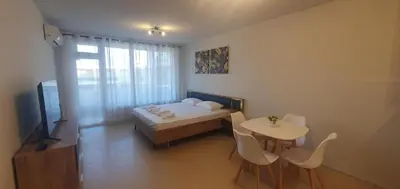 a bedroom with a bed and a table and chairs at Central Beach Ravda Apartments in Ravda