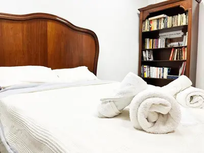 a bed with towels on it with a book shelf at Beehive Hotel and CoWorking in Varna City