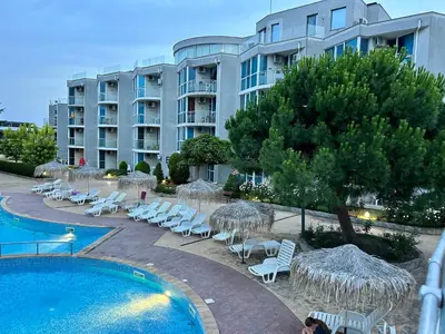 a resort with a pool and chairs and a building at Atlantis Resort & 4 swimming pools & Spa & Апартамент in Burgas City