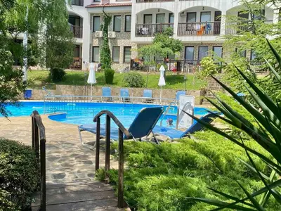 a swimming pool with a lounge chair next to a building at DELFIN Penthouse amazing view in Sveti Vlas