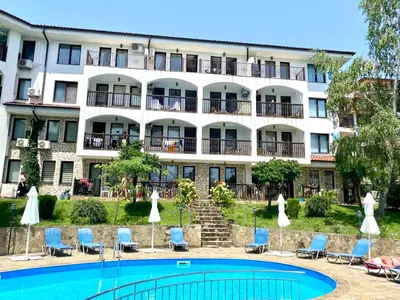 a hotel with a swimming pool in front of a building at DELFIN Penthouse amazing view in Sveti Vlas