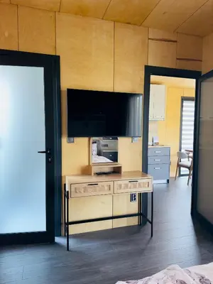 a living room with a tv and a table with a tvicterictericterswers at Holiday Village Smokinia in Sozopol