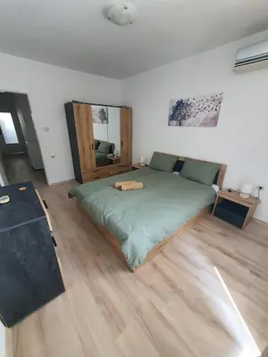 a bed in a room with a wooden floor at Apartament Lazur 13 in Burgas City