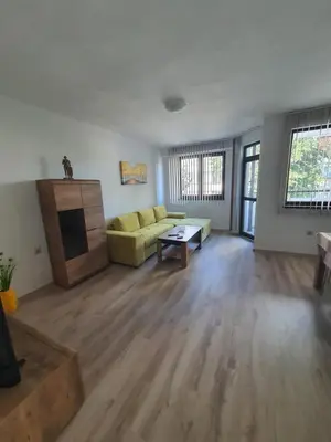 a living room with a yellow couch and a table at Apartament Lazur 13 in Burgas City