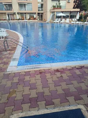a large swimming pool with blue water in a building at Kamelia Garden Apartment in Sunny Beach