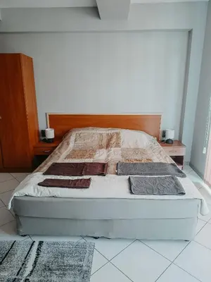 a bed sitting in a bedroom with two night stands at Kamelia Garden Apartment in Sunny Beach
