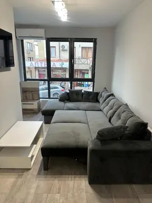 a living room with a large couch and a table at Апартамент - Весела улица in Sozopol