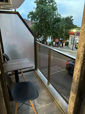 a bench sitting on a balcony with a view of a street at Апартамент - Весела улица in Sozopol