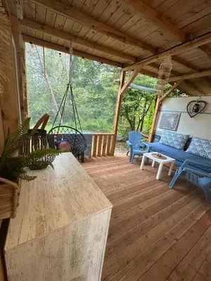 a screened in porch with a swing and a couch at Каравана Синята Маймуна плаж Градина # RV Blue Monkey on the beach in Chernomorets