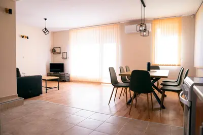 a living room with a dining room table and chairs at Къща за гости Далинда in Byala