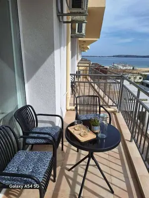 a balcony with chairs and a table on a balcony at Студио 310 на първа линия in Chernomorets