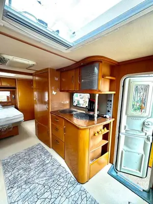 a kitchen with wooden cabinets and a refrigerator at Къмпинг Европа Юг in Burgas City