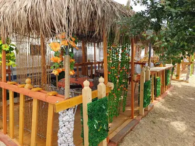 a gazebo with a straw roof and a fence at Къмпинг Европа Юг in Burgas City