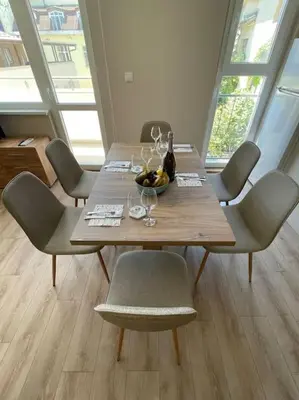 a wooden table with chairs and a bowl of fruit on it at Comfy home 2 - Burgas Centre in Burgas City
