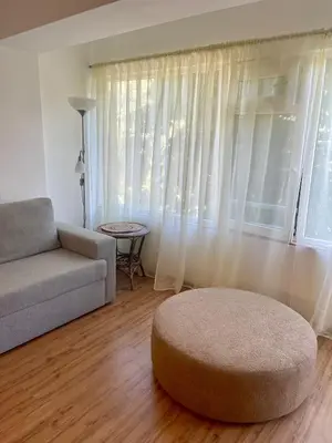 a living room with a couch and a large window at Varna city Park Apartament in Varna City