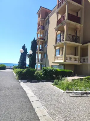 an apartment building with a sidewalk next to a street at Elenite Sea View Apartments in Elenite