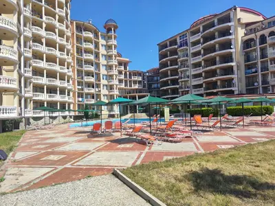 a pool with lounge chairs and umbrellas and buildings at Elenite Sea View Apartments in Elenite