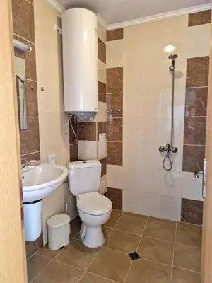 a bathroom with a toilet and a sink and a shower at Апартамент Бижу М in Pomorie