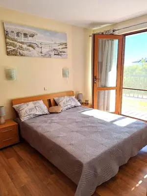 a bedroom with a large bed with a large window at Lidda Relax in Oasis Beach Kamchia in Bliznatsi