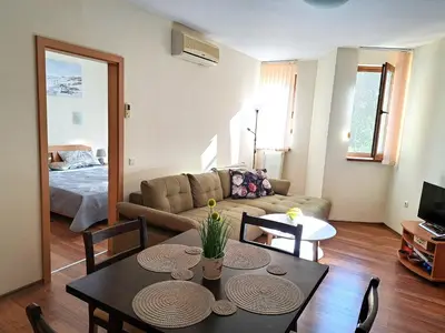 a living room with a table and a couch at Lidda Relax in Oasis Beach Kamchia in Bliznatsi