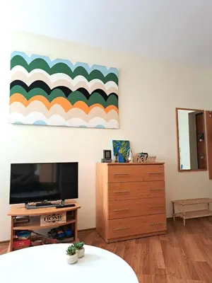 a living room with a television and a dresser at Lidda Relax in Oasis Beach Kamchia in Bliznatsi