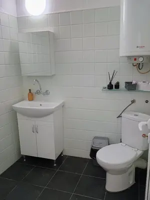 a bathroom with a white toilet and a sink at Васил Левски 61 in Burgas City