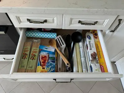 a cabinet filled with books and utensils at Апартамент Панорама Лазур in Burgas City