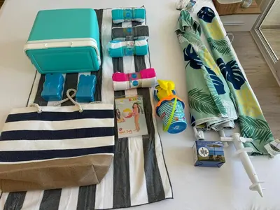 a table with a beach bag and a surfboard at Апартамент Панорама Лазур in Burgas City