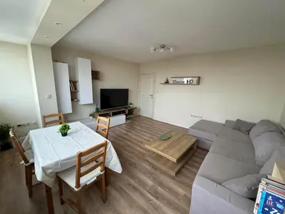 a living room with a couch and a table at Апартамент Панорама Лазур in Burgas City