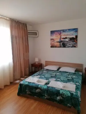 a bedroom with a bed with a green comforter at Апартаменти Захариеви 4 in Byala