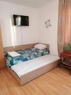 a bed in a room with a tv on the wall at Апартаменти Захариеви 4 in Byala