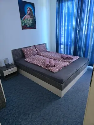 a bedroom with a bed with pink pillows on it at POMORIE Blue Bay in Pomorie