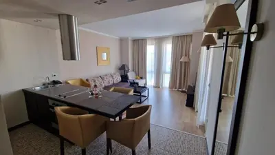 a kitchen and living room with a table and chairs at Apartment in Royal Beach Barcelo in Sunny Beach