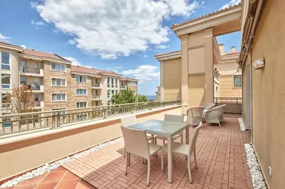 a patio with a table and chairs on a balcony at 2BD Flat with Balcony in Flores Garden Complex by Flat Mаnаger in Chernomorets