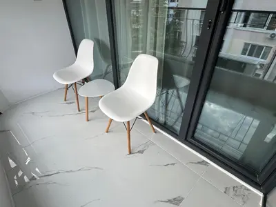 two white chairs sitting on top of a balcony at Studio Lazur in Burgas City