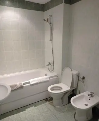 a bathroom with a toilet and a tub and a sink at Апартамент Къмпинг Градина in Chernomorets