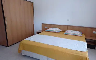 a bedroom with a large bed with two pillows at Апартамент Къмпинг Градина in Chernomorets