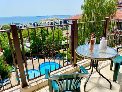 a balcony with a table and chairs and the ocean at DELFIN Sea view in Sveti Vlas