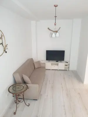 a living room with a couch and a tv at BOHO CHIC STUDIO Free parking upon request in Varna City