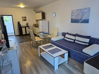 a living room with a blue couch and a table at POMORIE Luxury Appartment in Pomorie