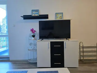 a flat screen tv sitting on top of a white entertainment center at POMORIE Luxury Appartment in Pomorie