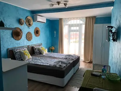 a bedroom with a bed with a blue wall at Студио - Морско бягство in Primorsko