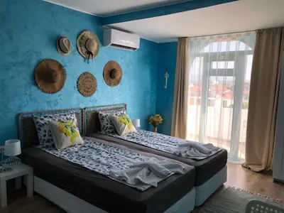 a bedroom with a bed with a blue wall at Студио - Морско бягство in Primorsko